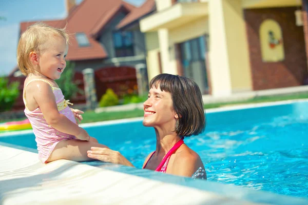 Sommerferien. hübsches kleines Mädchen mit ihrer Mutter im Schwimmbad im Freien — Stockfoto