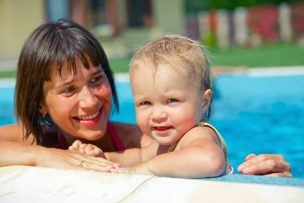 Vacances d'été. Jolie petite fille avec sa mère dans la piscine en plein air — Photo