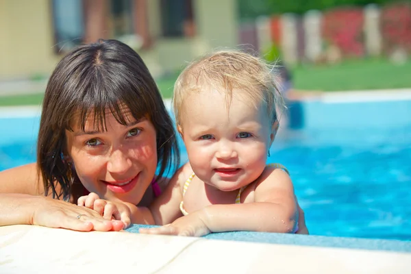 Letní prázdniny. docela holčička s maminkou v plavecký bazén venkovní — Stock fotografie