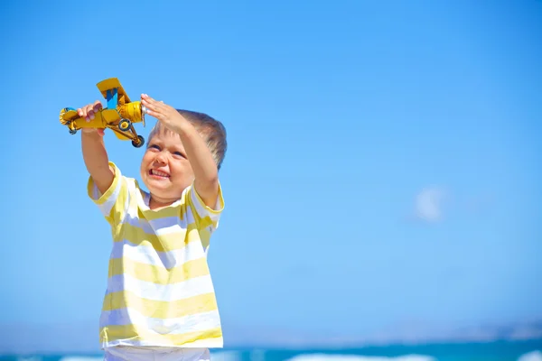 Menino brincando com um avião de brinquedo — Fotografia de Stock