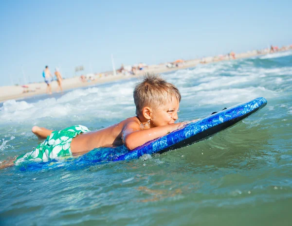 Boy has fun with the surfboard — Stock Photo, Image