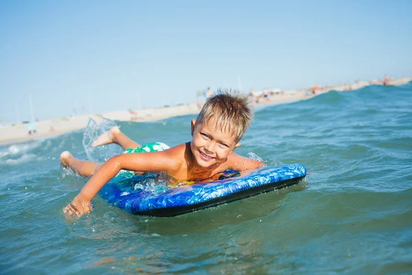Chłopiec ma zabawy z deski surfingowej — Zdjęcie stockowe