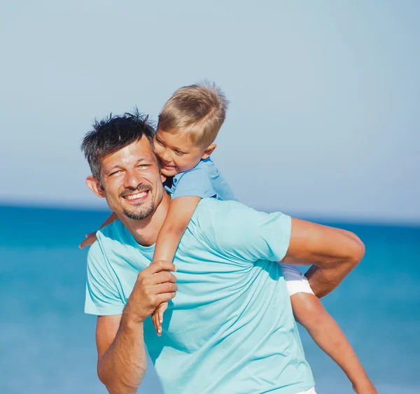 Far och son på stranden — Stockfoto