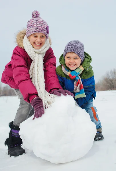 Barnen gör en snögubbe — Stockfoto