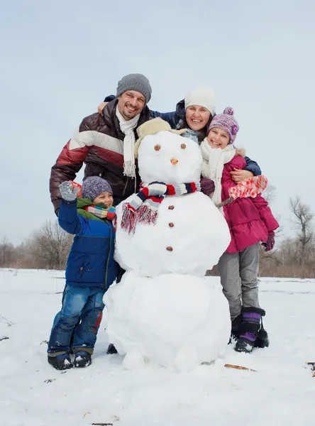 Familjen göra en snögubbe — Stockfoto