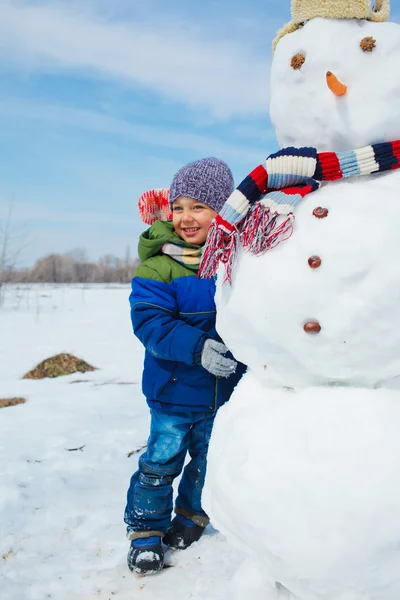 Rapaz faz um boneco de neve — Fotografia de Stock