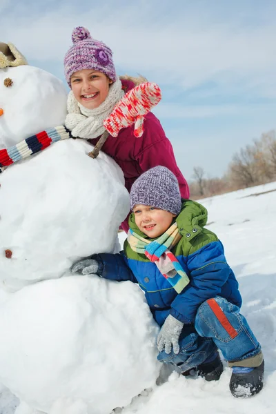 Les enfants font un bonhomme de neige — Photo