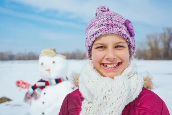 Menina com um boneco de neve — Fotografia de Stock