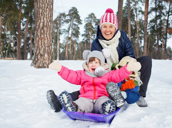 Funny family is sledging in winter-landscape — Stock Photo, Image