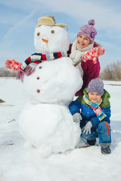 Barnen gör en snögubbe — Stockfoto