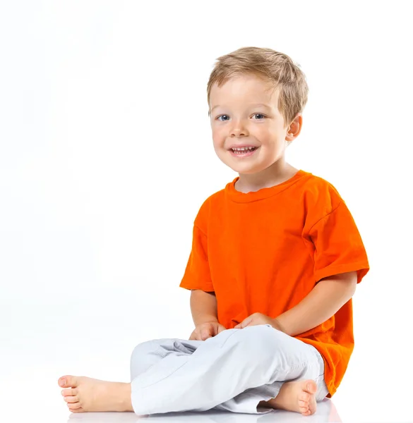 Счастливый мальчик сидит на полу — стоковое фото