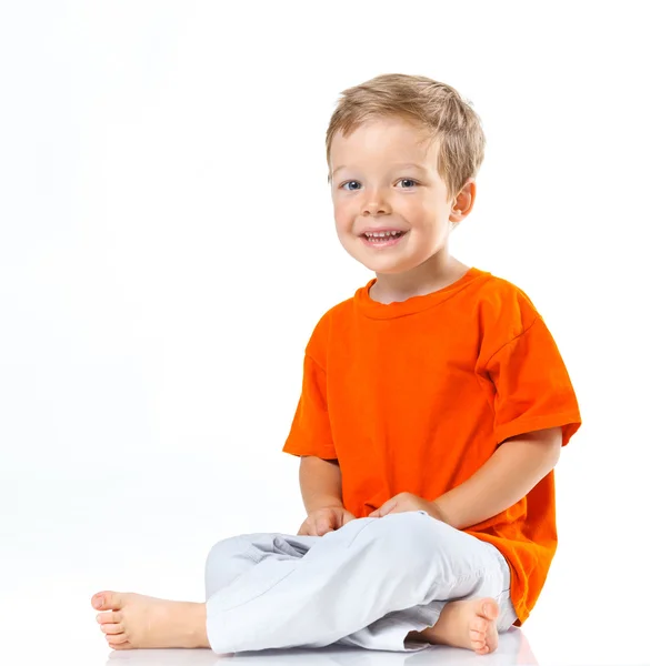 Glücklicher Junge auf dem Boden sitzend — Stockfoto