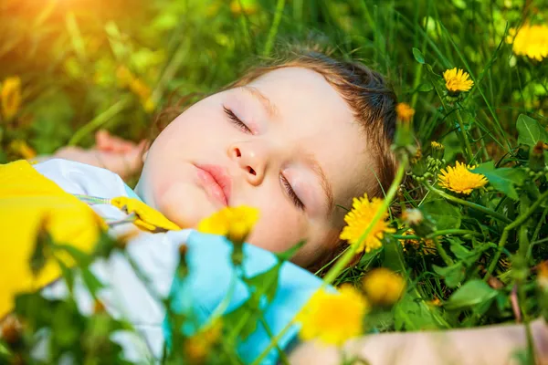 Menino adormecido na grama — Fotografia de Stock