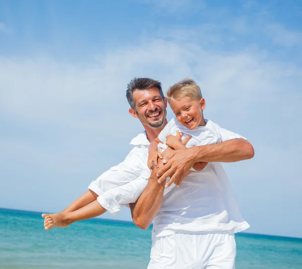 Pai e filho se divertindo na praia — Fotografia de Stock