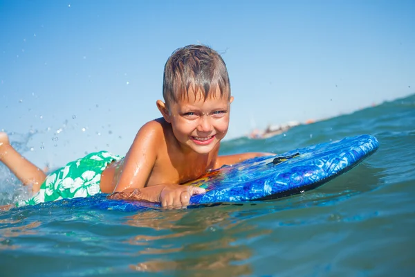 Pojken har kul med surfbräda — Stockfoto