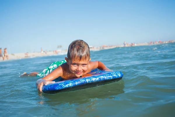 Boy has fun with the surfboard — Stock Photo, Image