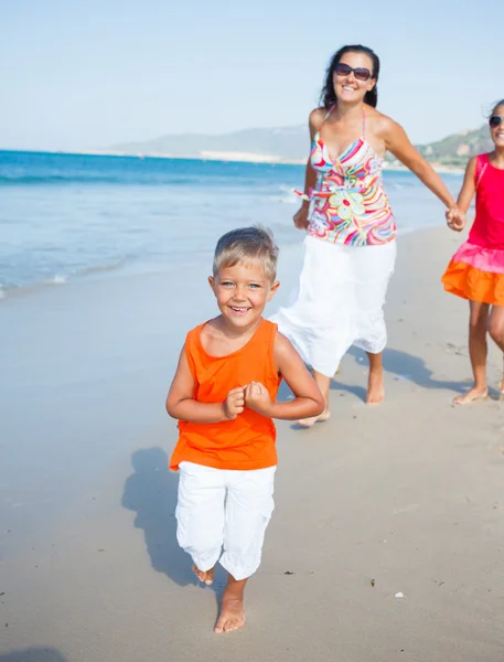 Schattige jongen met zus en moeder op het strand — Stockfoto