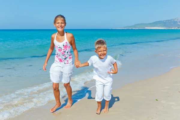 Leuke jongen en meisje op het strand — Stockfoto