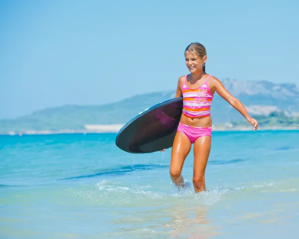 Mädchen mit Surfbrett im Ozean — Stockfoto