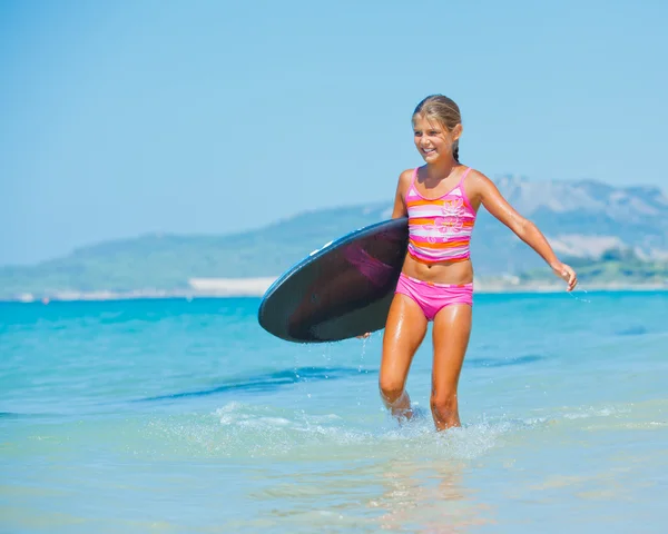 Fille avec planche de surf dans l'océan — Photo