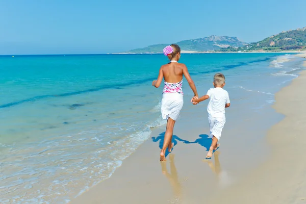 Mignon garçon et fille sur la plage — Photo