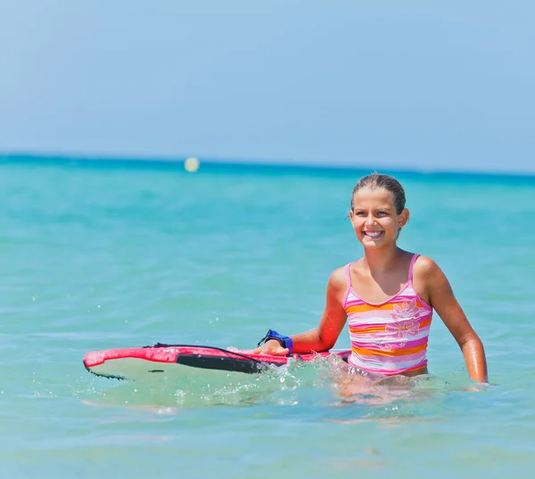 Søt jente med surfebrett. – stockfoto