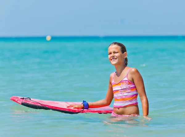 Милая девушка с доской для серфинга — стоковое фото
