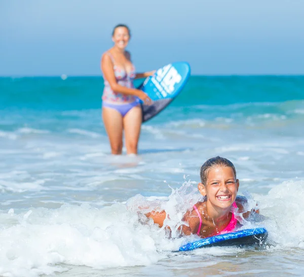 Mädchen und Mutter mit Surfbrettern — Stockfoto