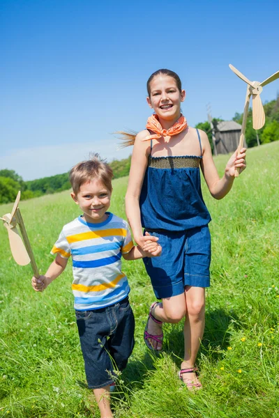 Barnen i sommardag rymmer väderkvarn — Stockfoto