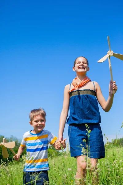 Enfants en journée d'été tient moulin à vent — Photo