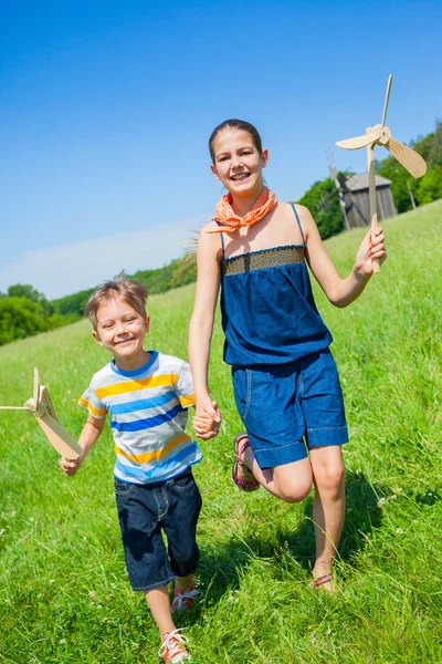 Crianças no dia de verão detém moinho de vento — Fotografia de Stock
