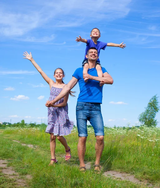 Glücklicher Vater mit Kindern im Freien gegen den Himmel — Stockfoto