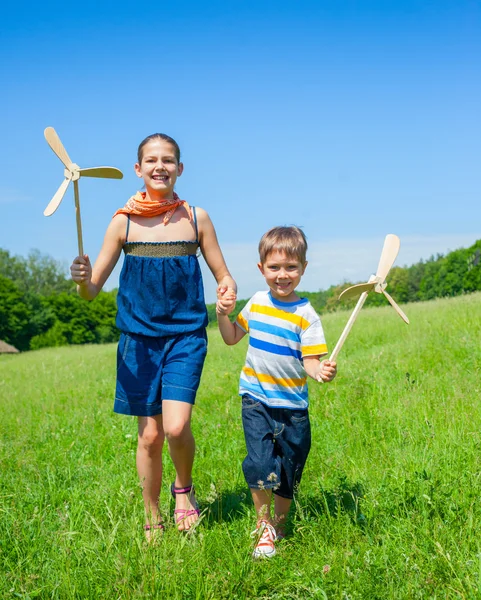 Niños en verano día sostiene molino de viento —  Fotos de Stock