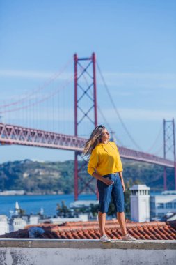 Portekiz turist çekimleri konsepti. Çekici esmer kız ve 25 Nisan Köprüsü Lizbon