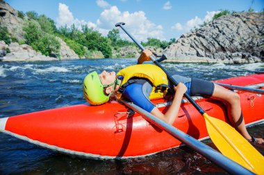 Yaz tatilinde güneşli bir günde nehirde kano yapan tatlı çocuk.
