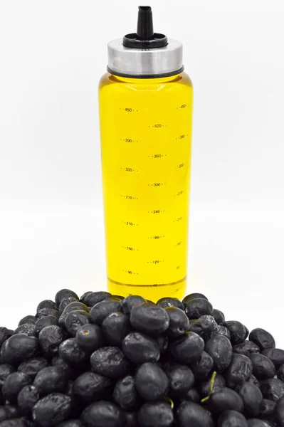 新鮮なおいしい黒トルコのオリーブと黄金のオリーブオイルボトル 白い背景に隔離された — ストック写真