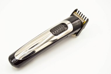 Kablosuz ve krom elektrikli tıraş makinesi ve turuncu şarj aleti, beyaz arka planda izole edilmiş saç makasıyla dolu.