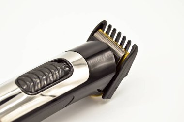 Kablosuz ve krom elektrikli tıraş makinesi ve turuncu şarj aleti, beyaz arka planda izole edilmiş saç makasıyla dolu.