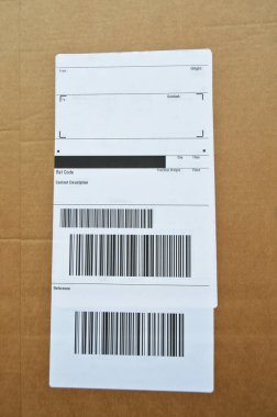 Kahverengi ve bej renkli karton zarflar yapışkan barkodların üzerinde. Şirket yazışmalarında kullanılabilir.