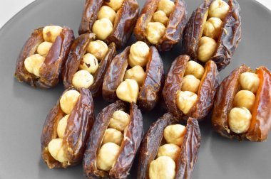 Organik taze besleyici kurutulmuş hurma, tarihin içine yerleştirilmiş fındık ve jool taneleri, gri bir tabakta.