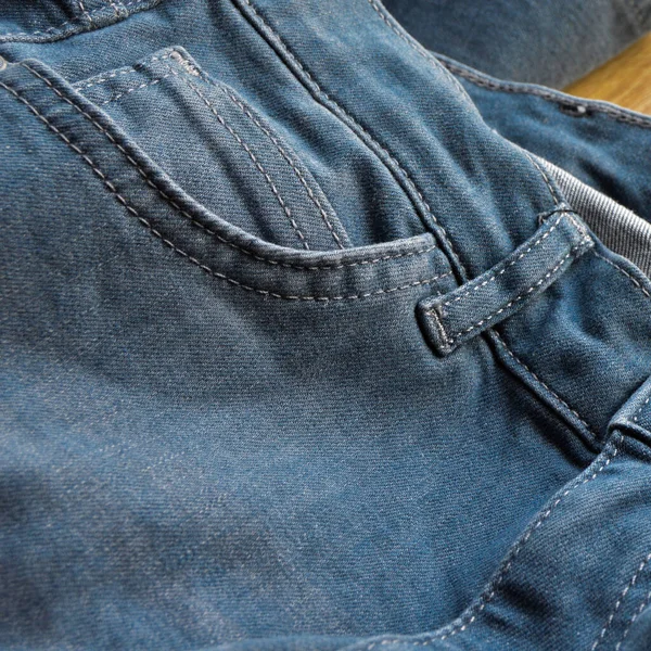 木製の床にライトブルーのジーンズデニムのポケットの詳細を閉じます — ストック写真