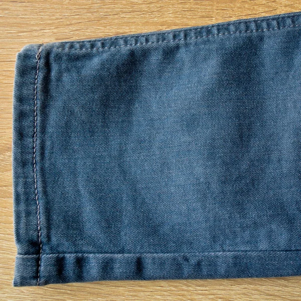 松软蓝色斜纹棉布牛仔裤腿细节 面料质地背景和墙纸 木制地板 — 图库照片