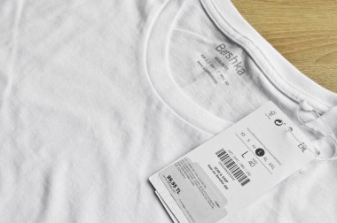 Yeni beyaz Bershka tişörtü ve boş etiket, tahta zeminde, 01 Mayıs 2022 İstanbul Maltepe Türk Bershka mağazası