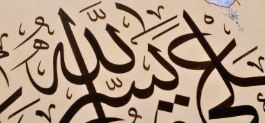 El yapımı kaligrafi kalemi ve İslam sanatı ile kağıt üzerinde İslam kaligrafi karakterleri