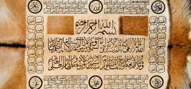 Deri üzerine el yapımı kaligrafi kalemi ve İslam sanatı ile İslam kaligrafi karakterleri.