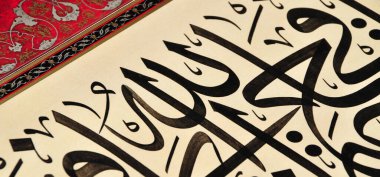El yapımı kaligrafi kalemi ve İslam sanatı ile kağıt üzerinde İslam kaligrafi karakterleri