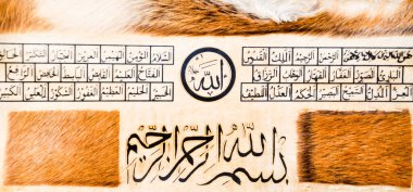 Deri üzerine el yapımı kaligrafi kalemi ve İslam sanatı ile İslam kaligrafi karakterleri.