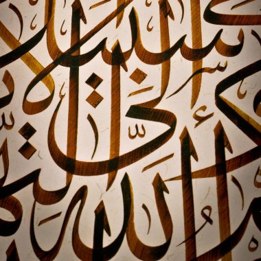 El yapımı kaligrafi kalemi, İslam sanatı ve Allah 'ın adıyla kağıt üzerinde İslam kaligrafi karakterleri.
