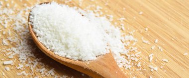 Tahta kaşık içinde taze ve besleyici hindistan cevizi, bambu kesme tahtasında.