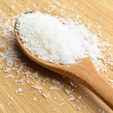 Tahta kaşık içinde taze ve besleyici hindistan cevizi, bambu kesme tahtasında.